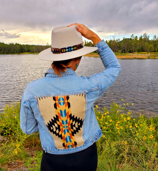 Model is standing, looking at lake wearing upcycled denim jacket with Pendleton® wool patches and panel.